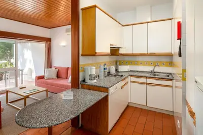 a kitchen with white cabinets and a counter top at Apartamentos Turisticos Pinhal Da Marina in Vilamoura