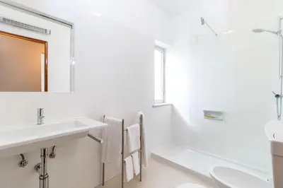 a white bathroom with a sink and a mirror at Apartamentos Turisticos Pinhal Da Marina in Vilamoura