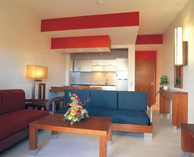 a living room with a blue couch and a table at Hotel Apartamento Balaia Atlantico in Albufeira