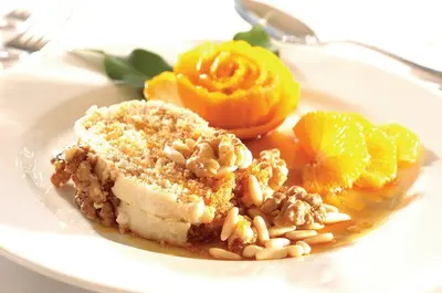 a plate of food with a piece of cake and fruit at Hotel Apartamento Balaia Atlantico in Albufeira