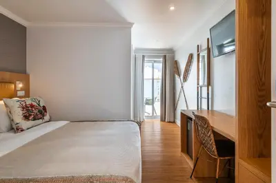 a white bedroom with a white bed and a window at Vila Sao Vicente Boutique (Adults Only) in Albufeira