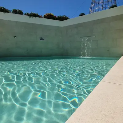 a swimming pool with a water fountain at Hospedaria Frangaria in Faro