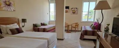 a hotel room with two beds and a chair at Hospedaria Frangaria in Faro