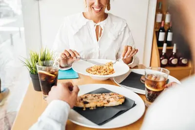 a woman sitting at a table with a plate of food at Stay Hotel Faro Centro in Faro