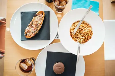 a table with plates of food and a bowl of noodles at Stay Hotel Faro Centro in Faro