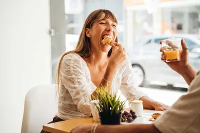 a woman sitting at a table eating food at Stay Hotel Faro Centro in Faro