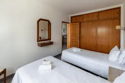 two beds in a hotel room with a mirror at Parque Monte Verde in Albufeira