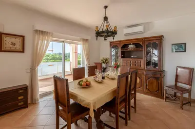 a kitchen and dining room with a table and chairs at Parque Monte Verde in Albufeira