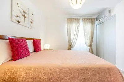 a bedroom with a large bed with pink pillows at My Place @ Faro City Views in Faro