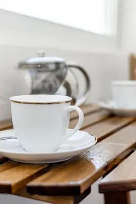 a cup of coffee sitting on a wooden table at My Place @ Faro City Views in Faro