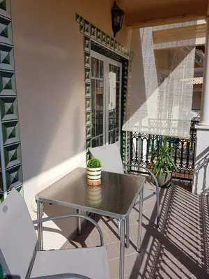 a patio with a table and chairs on a balcony at Seashell Apartment OURA in Albufeira