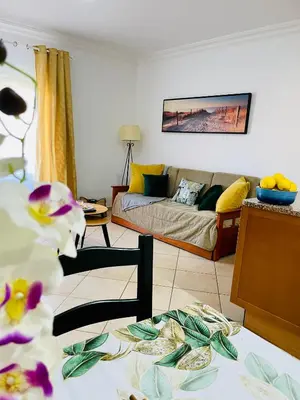 a living room with a couch and a table at Seashell Apartment OURA in Albufeira