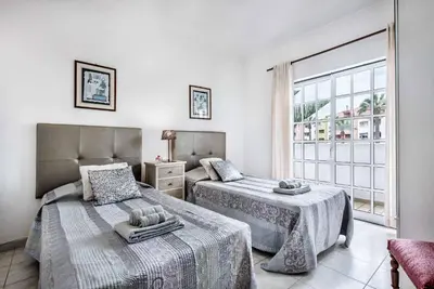 a bedroom with two beds and a large window at Villa Torcato in Albufeira