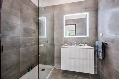 a bathroom with a shower and a sink and a mirror at Villa Torcato in Albufeira