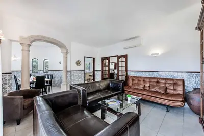 a living room with leather couches and a table at Villa Torcato in Albufeira