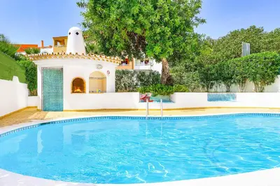 a swimming pool in front of a house at Villa Torcato in Albufeira