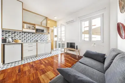 a living room with a couch and a kitchen at RG Downtown Duplex in Faro