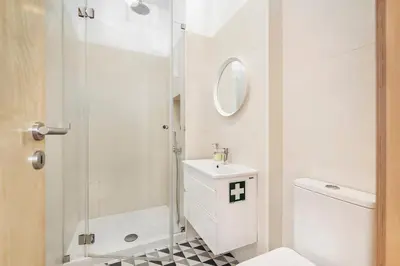 a bathroom with a toilet and a sink and a shower at RG Downtown Duplex in Faro