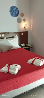 a bedroom with a red bed with two pillows on it at Hotel Alnacir in Faro