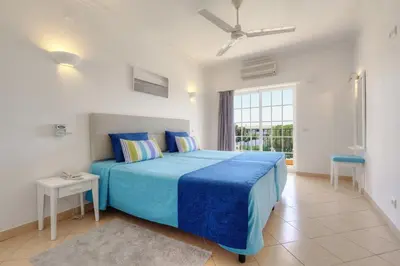 a bedroom with a blue bed and a window at 3HB Clube Humbria - All Inclusive in Albufeira