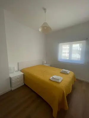 a white cabinet with a mirror and a vase on it at Apartamentos Carteia in Quarteira