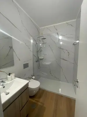 a bathroom with a glass shower and a toilet at Apartamentos Carteia in Quarteira