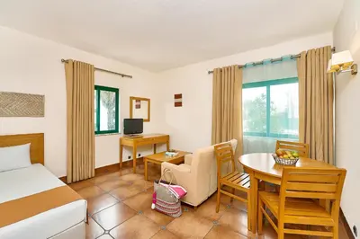 a hotel room with a bed and a table and chairs at Oceanus Aparthotel in Albufeira