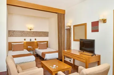 a hotel room with two beds and a television at Oceanus Aparthotel in Albufeira