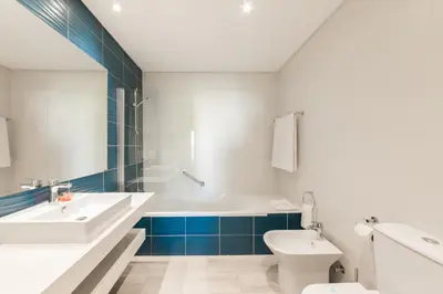 a bathroom with a tub and a sink and a toilet at Clube Albufeira Garden Village in Albufeira