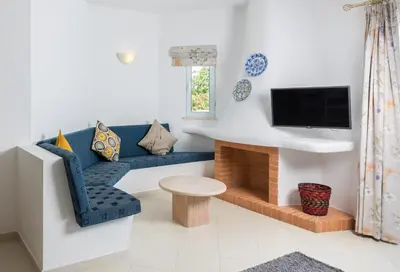 a living room with a blue couch and a tv at Clube Albufeira Garden Village in Albufeira