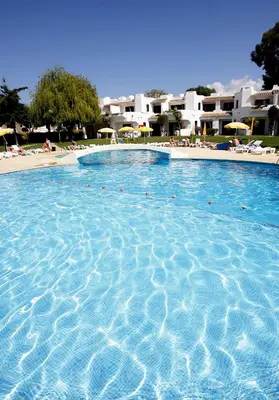 a large blue swimming pool with people in it at Clube Albufeira Garden Village in Albufeira