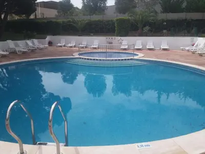 a large swimming pool with chairs and a table at Aldeia Da Falesia in Albufeira