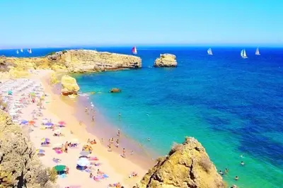 a group of people on a beach near the ocean at 60m2 Lovely traditional apartment in Clube Albufeira in Albufeira