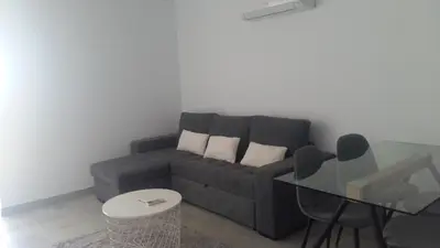 a living room with a couch and a glass table at Orange Studio in Vilamoura