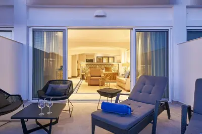 a living room with chairs and tables and a living room at Dona Filipa Hotel in Vale do Lobo