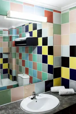a bathroom with a sink and a colorful tiled wall at Bayside Salgados in Albufeira