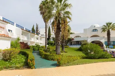 a hallway with chairs and stairs in a building at Grand Muthu Oura View Beach Club in Albufeira