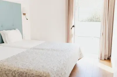 a white bedroom with a bed and a window at Vila Channa - Adults Only in Albufeira