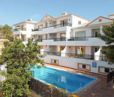 an apartment building with a swimming pool in front of it at Alfagar Cerro Malpique in Albufeira