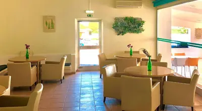 a restaurant with two tables and chairs and a window at Albufeira Jardim by Umbral in Albufeira