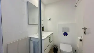 a white bathroom with a toilet and a sink at Galo by Check-in Portugal in Albufeira