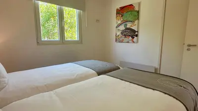 two beds in a room with a window at Galo by Check-in Portugal in Albufeira
