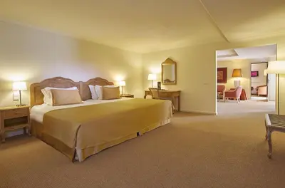 a hotel room with a large bed and a living room at PortoBay Falesia in Albufeira