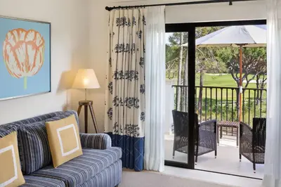 a living room with a couch and a sliding glass door at Pine Cliffs Residence, a Luxury Collection Resort, Algarve in Albufeira