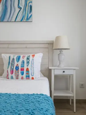 a bed with a pillow and a table with a lamp at Casa Mar d'Alma - 100m from the Beach in Albufeira