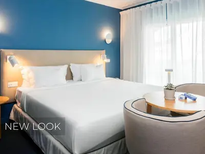 a hotel room with a large bed and a table at Velamar Boutique Hotel - Adults Friendly in Albufeira