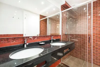 two sinks in a bathroom with red tiles at Victory Village Club 9F in Quinta do Lago