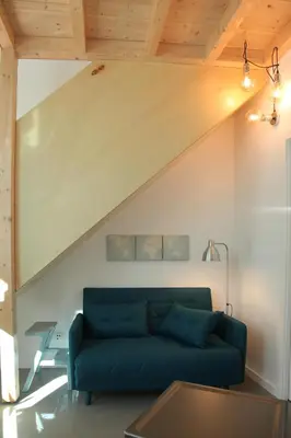 a living room with a blue couch and a table at Dubocage45Citycenter in Faro