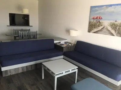 a living room with a blue couch and a table at Almar Hotel Apartamento in Albufeira