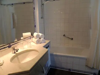 a bathroom with a sink and a tub and a shower at Almar Hotel Apartamento in Albufeira